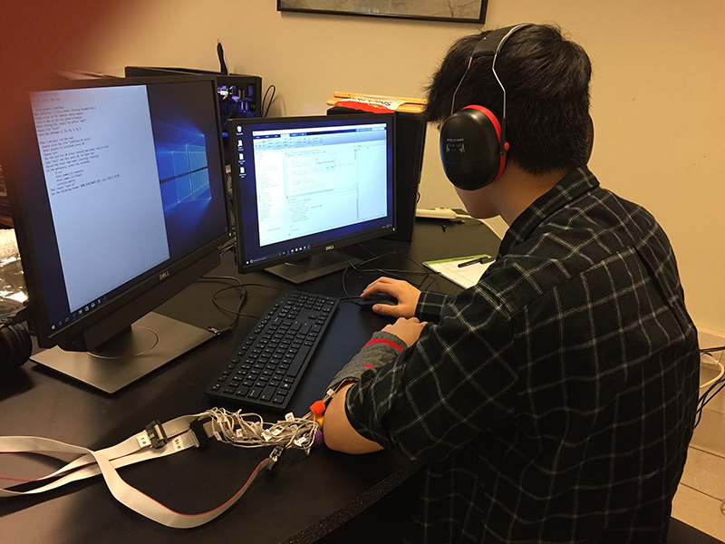 Kevin Tan, a participant in the study, learns English sounds through haptic communication technology developed by Purdue researchers. The device plays specific sensations on the user’s forearm, as he notes the corresponding English phoneme, or the smallest unit of sound. (Image provided)